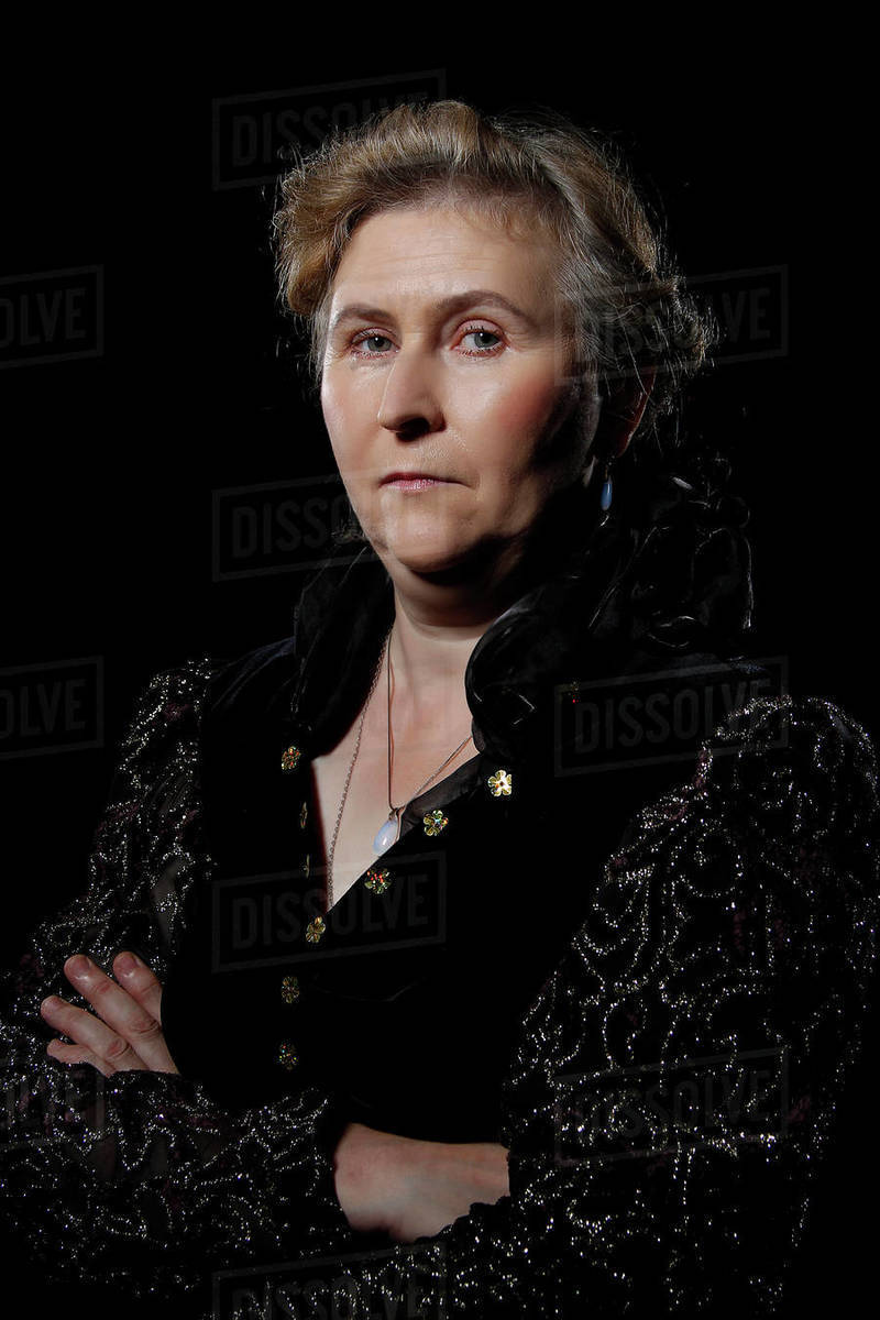 elderly woman on black background.Evil woman. An elderly woman with an