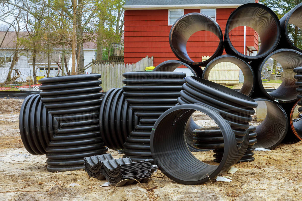 Plastic PVC pipes stacked in rows at construction site on reconstruction of the city drain