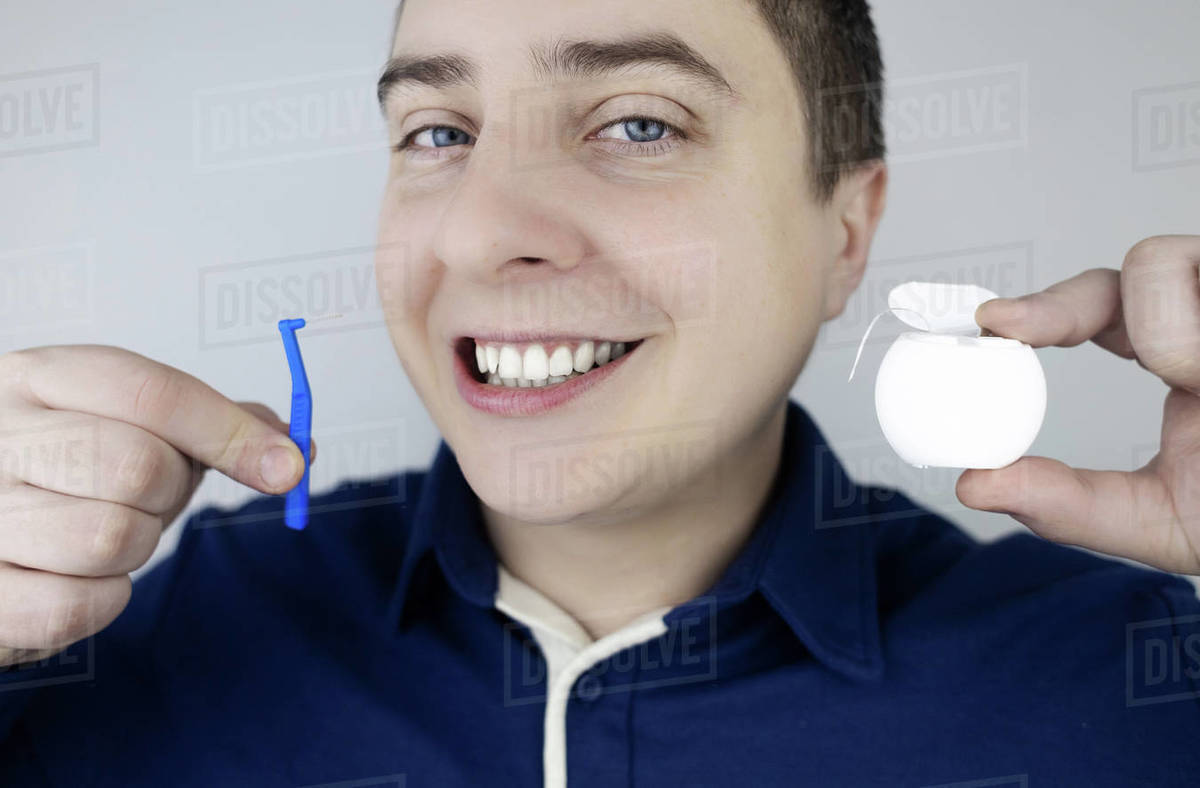 Interdental brush. A man shows a brush for cleaning the interdental