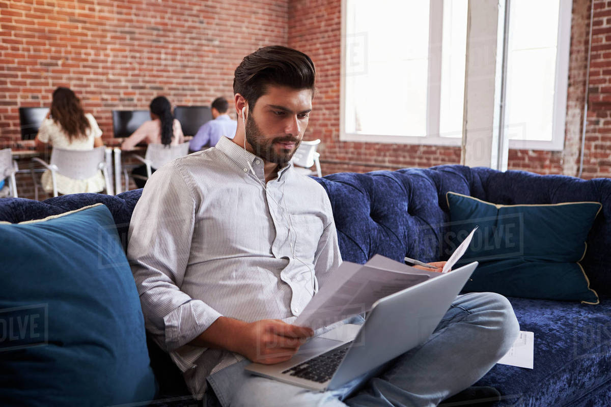 Businessman working on sofa in modern creative office Stock Photo