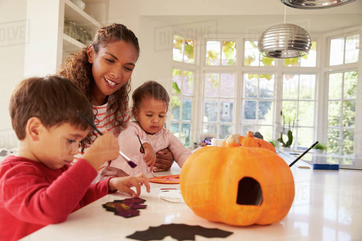 Mother and children making halloween decorations at home Stock Photo