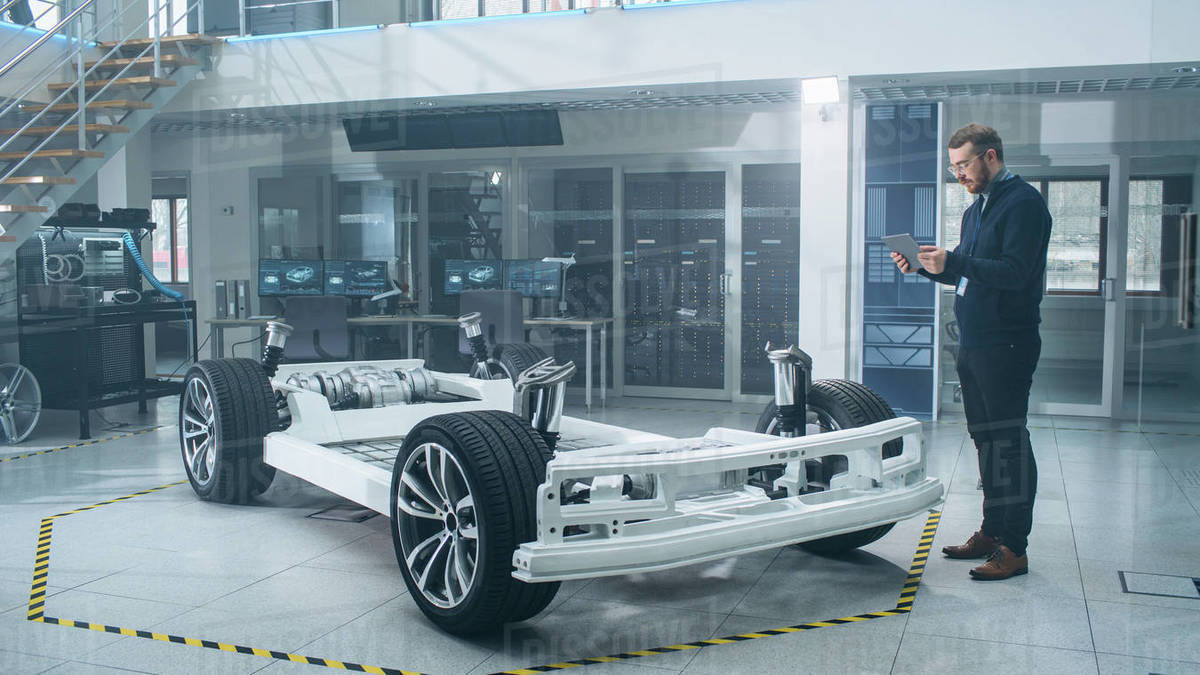 Engineer with Glasses and Beard Scans Electric Car Chassis Prototype