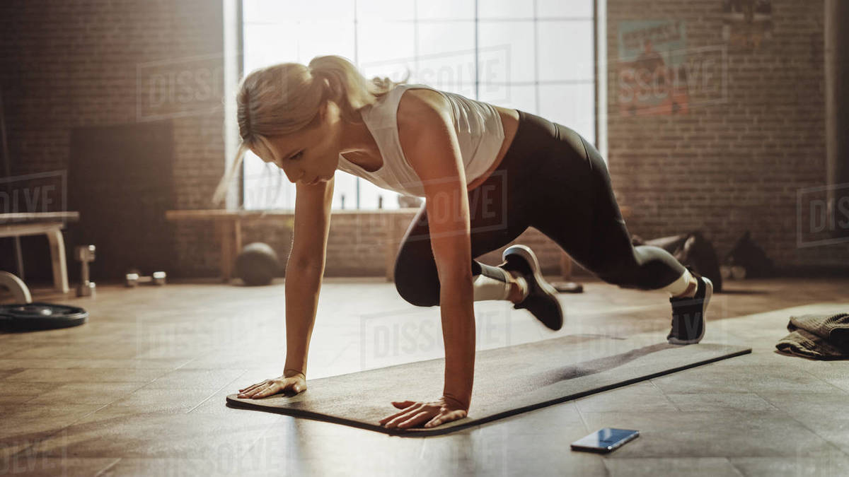 Beautiful and Young Girl Doing Running Plank on Her Fitness Mat