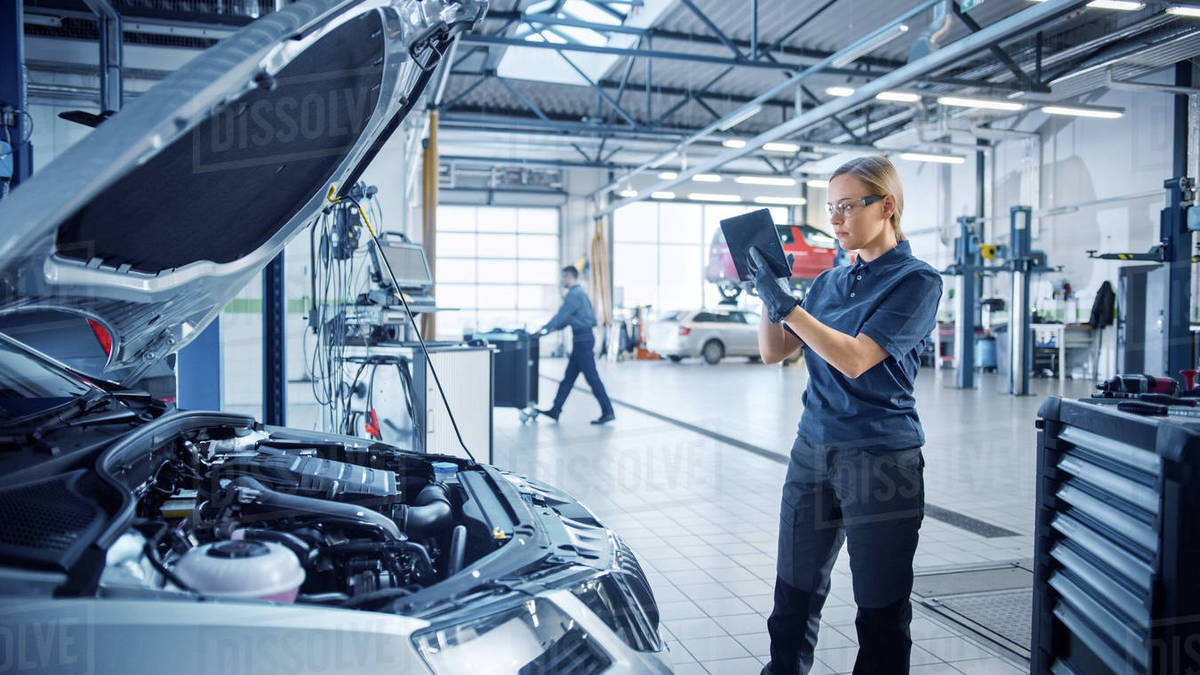 Female Mechanic Uses a Tablet Computer with an Augmented Reality