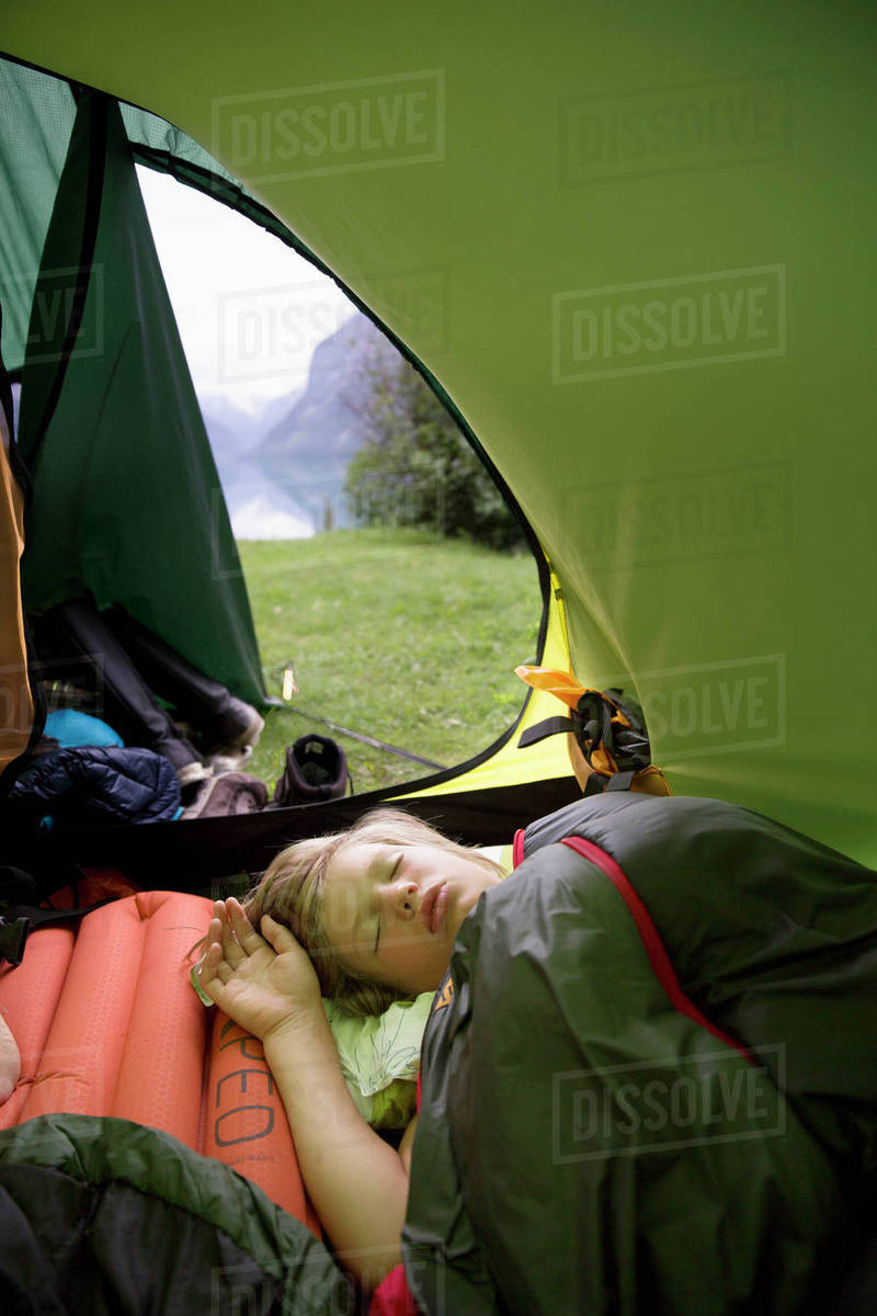 Boy sleeping in tent Stock Photo Dissolve