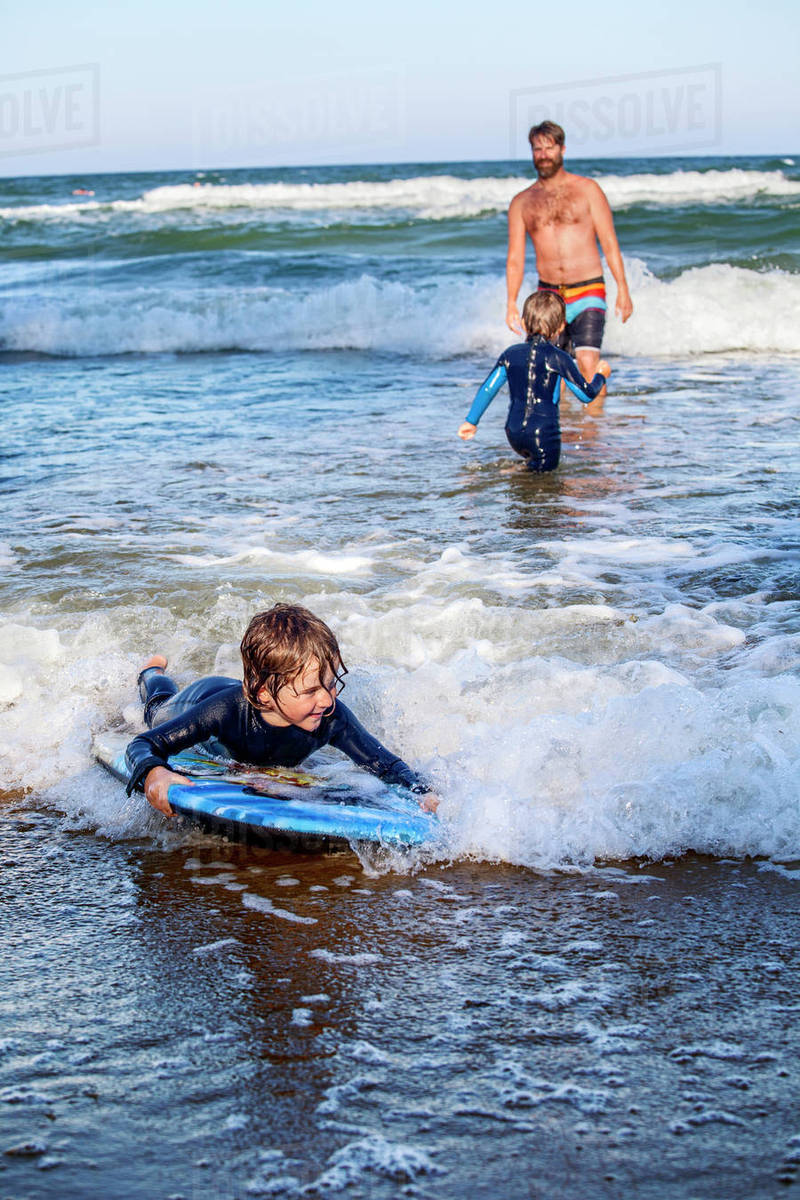 Father with sons surfing Stock Photo Dissolve