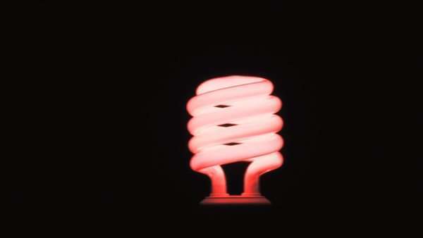 Panning Left To Right Of Red Fluorescent Light Bulb In Dark Room Against Black Background Stock Footage Panning Left To Right Of Red Fluorescent Light Bulb In Dark Room Against Black Background Stock Footage