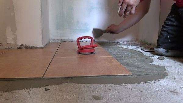 zoom in of man straighten tile on the cement surface with laser zoom in of man straighten tile on the cement surface with laser