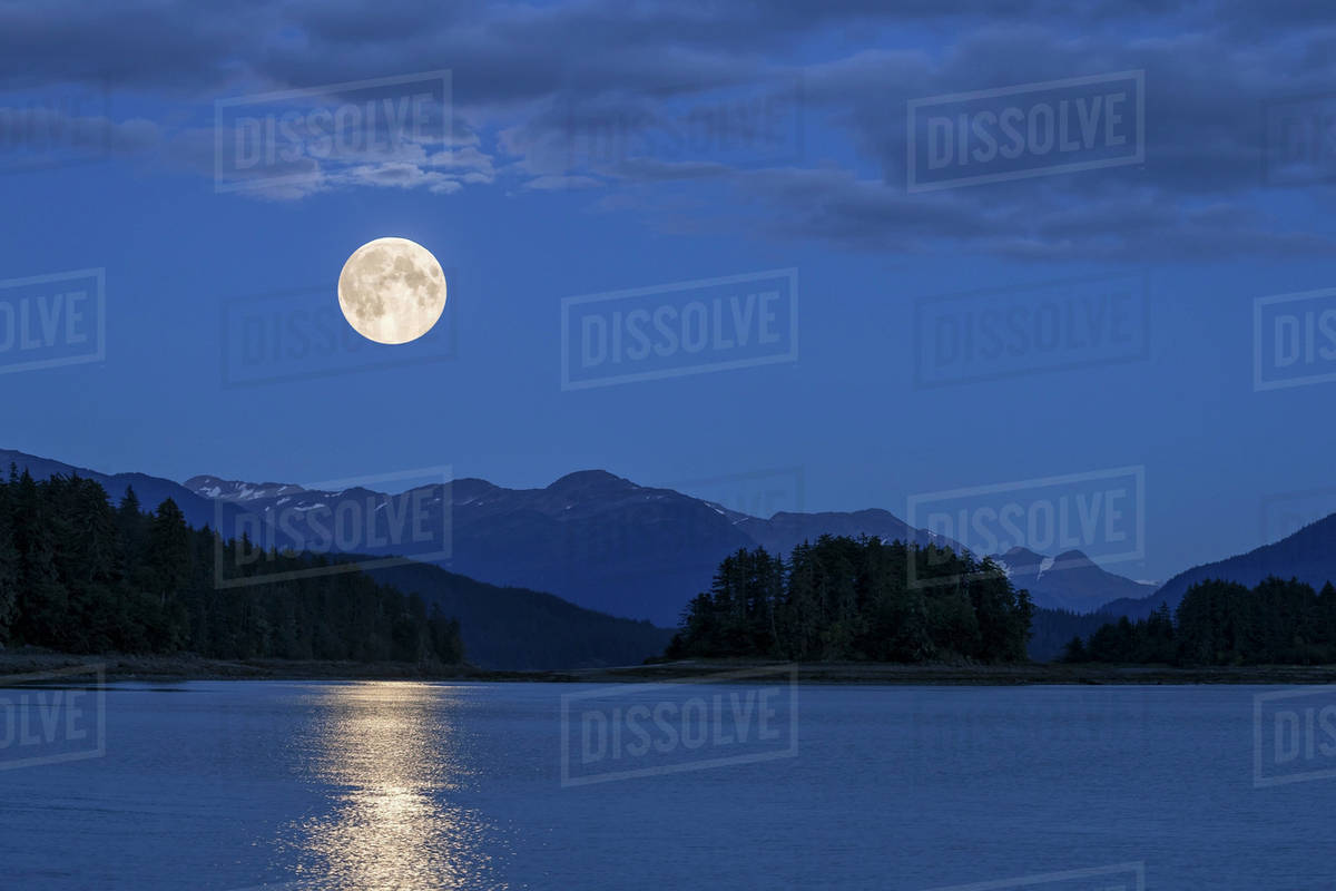 A full Moon rises over Auke Bay, Juneau, Southeast Alaska. Stock