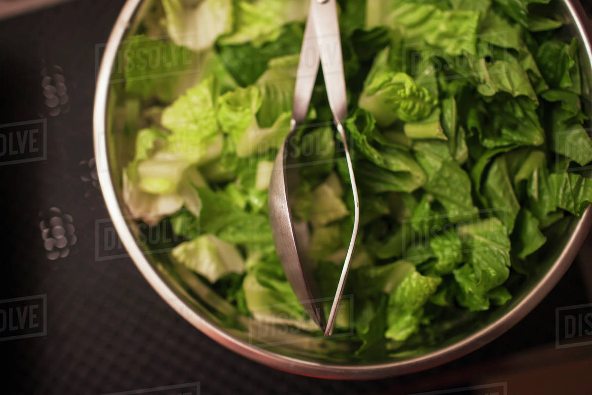 Salad in a bowl with serving tongs Stock Photo Dissolve