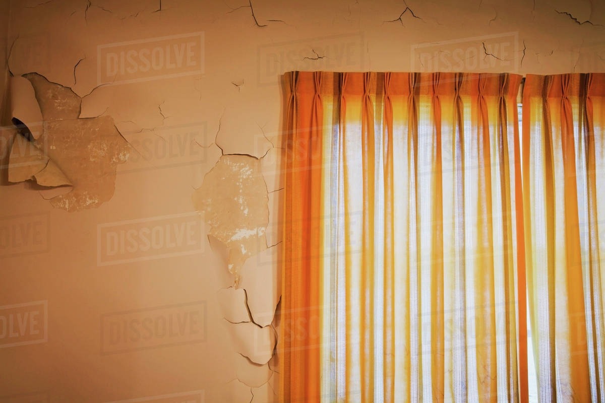 Wall With Cracked And Peeling Paint And Old Orange Curtains In A