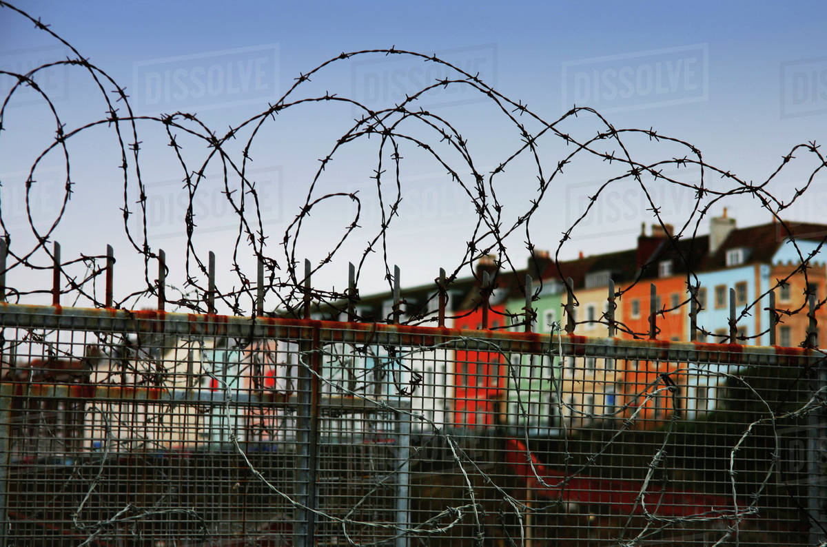Row Houses Seen From Behind A Barbed Wire Fence; Bristol England Stock Photo Dissolve