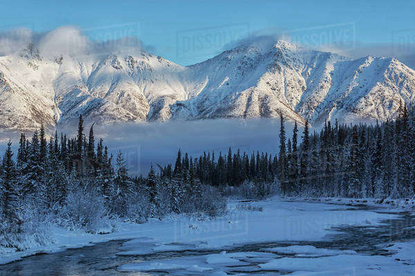 Grey ridge looms over the Wheaton River near Whitehorse; Yukon, Canada ...
