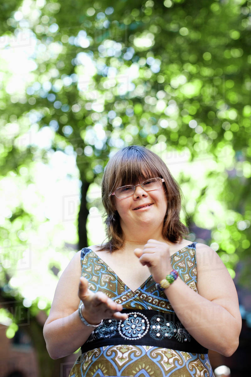 Portrait of young woman with down syndrome clenching her fist using