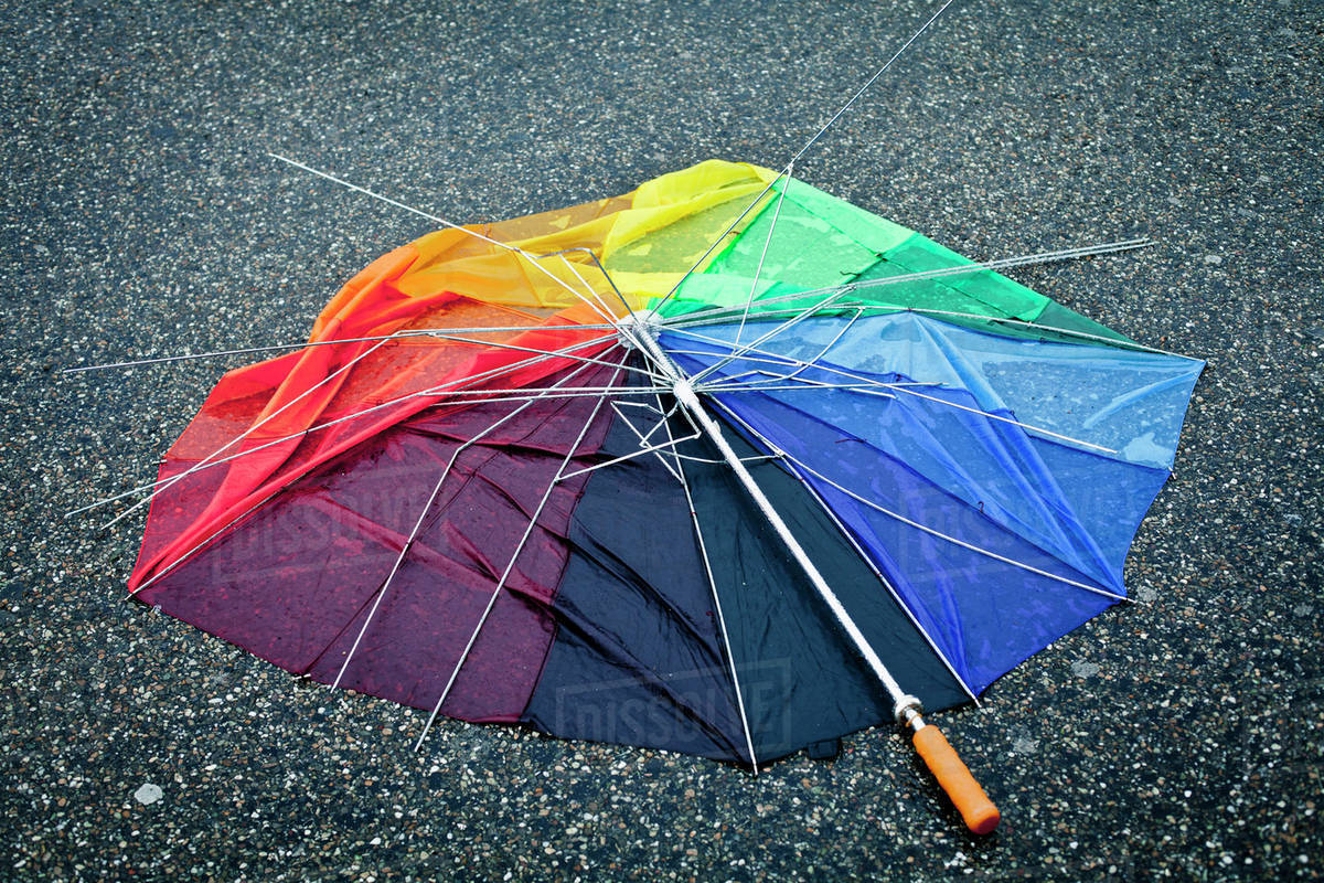 Multi colored broken umbrella on street Stock Photo Dissolve