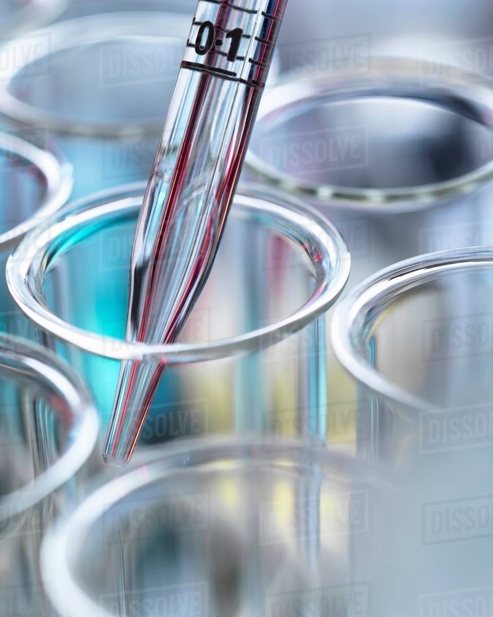 High angle cropped view of graduated pipette pipetting liquid into test