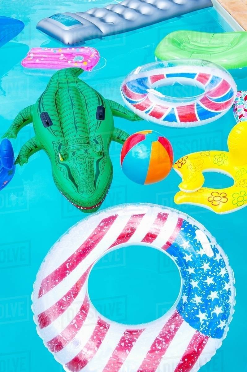 Air mattresses floating on swimming pool Stock Photo Dissolve