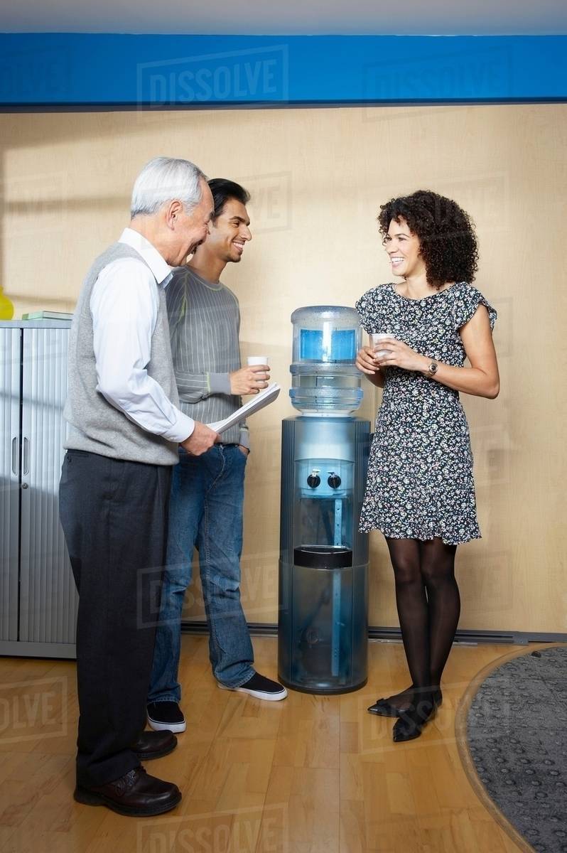 Casual meeting by office water cooler Stock Photo Dissolve