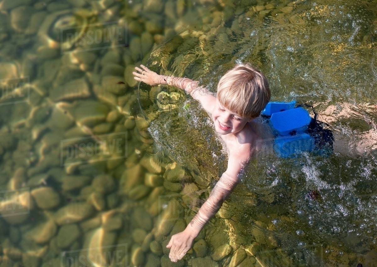 Boy swimming with swimming belt Stock Photo Dissolve