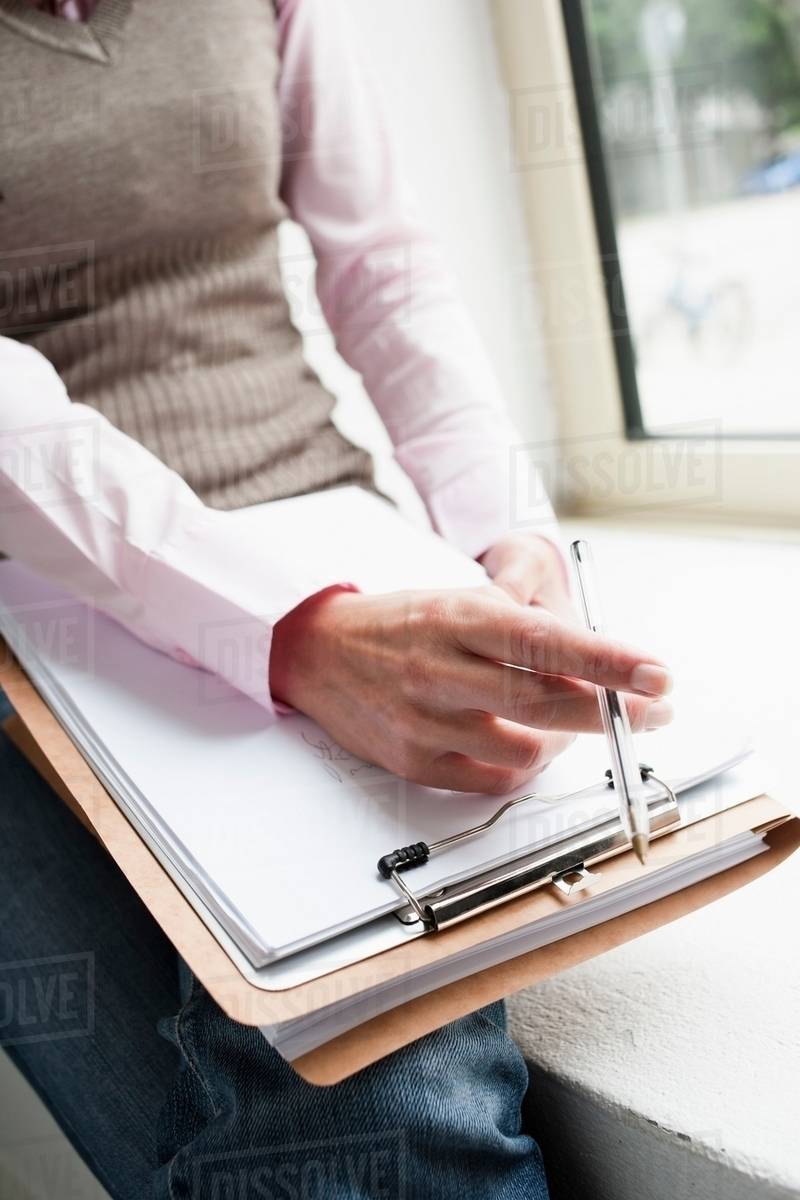 Hand holding clipboard closeup Stock Photo Dissolve