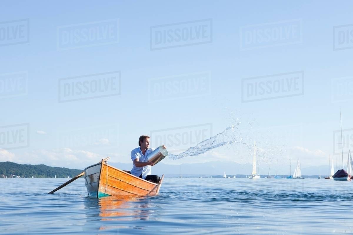 Throwing buckets of water ot ouf boat Stock Photo Dissolve