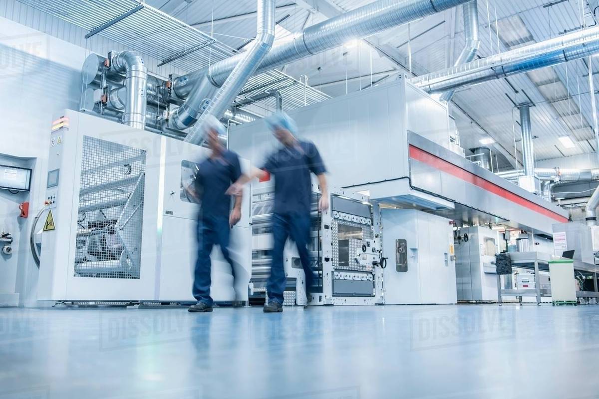 Workers with printing machine in food packaging printing factory