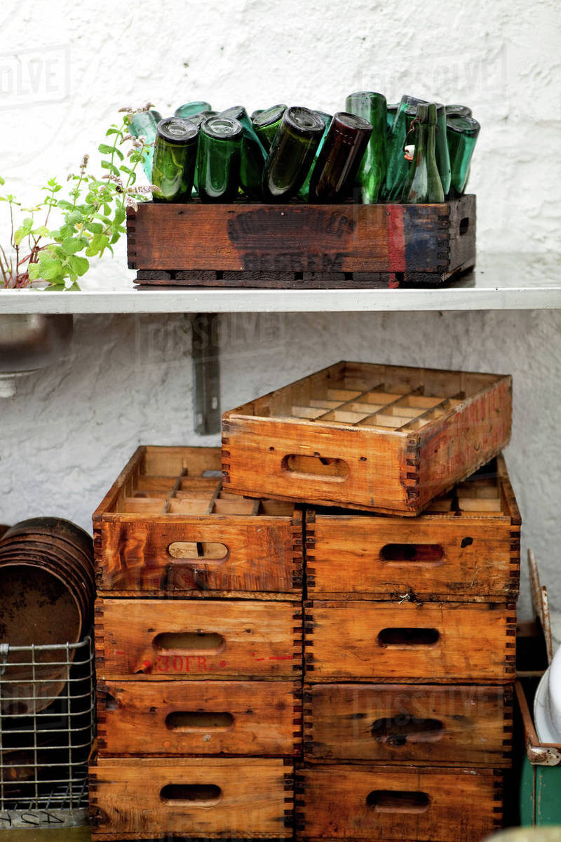 Stack Of Wooden Crates And Upside Down Vintage Bottles On Terrace In Stack Of Wooden Crates And Upside Down Vintage Bottles On Terrace In Rain