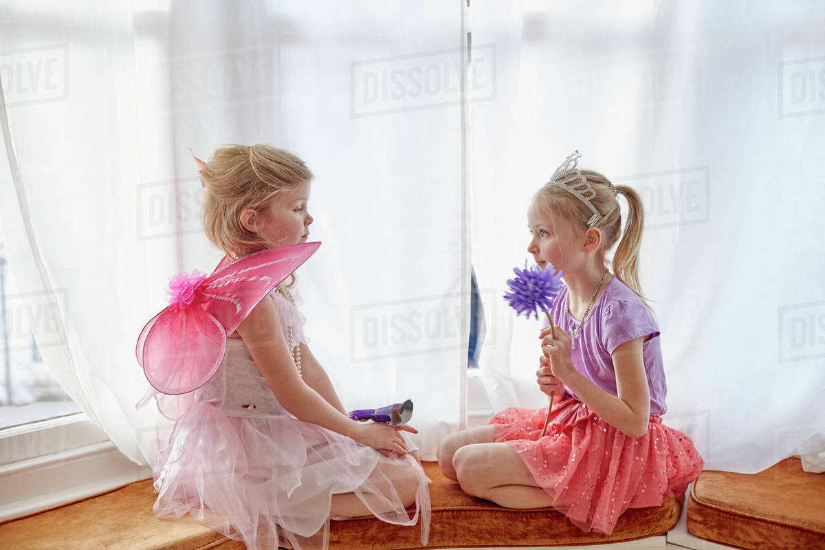 Two young girls, in fancy dress, sitting face to face Royalty-free stock photo