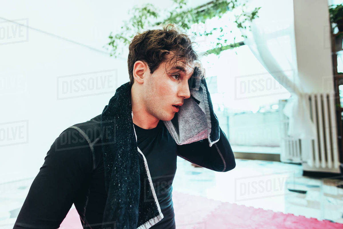 Man wiping brow with towel Stock Photo Dissolve