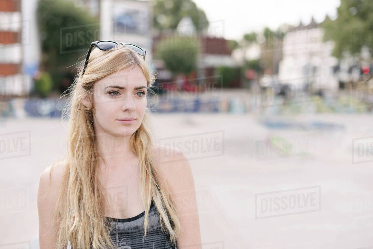 Portrait of young female skateboarder with long blond hair in skatepark Royalty-free stock photo