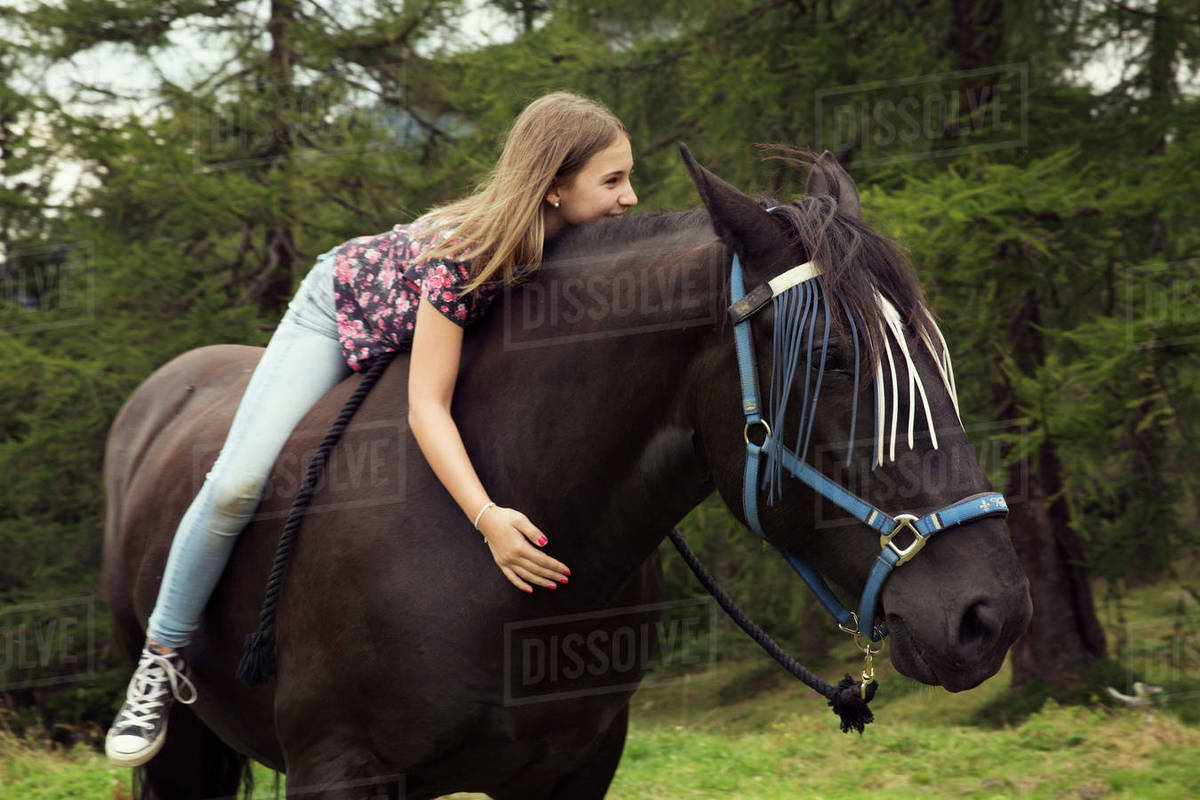 Girl sitting bareback on horse in forest glade, Sattelbergalm, Tyrol
