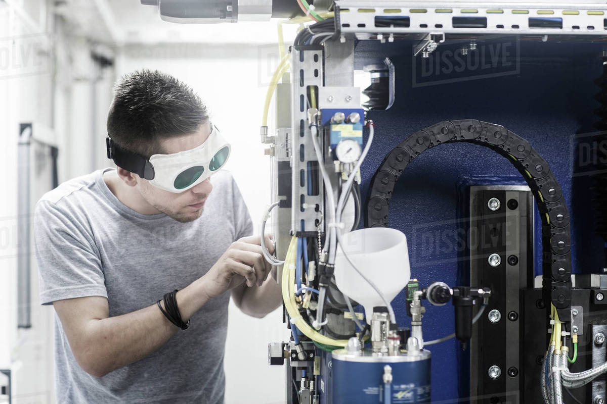 Engineer, wearing safety goggles, working in engineering plant Stock