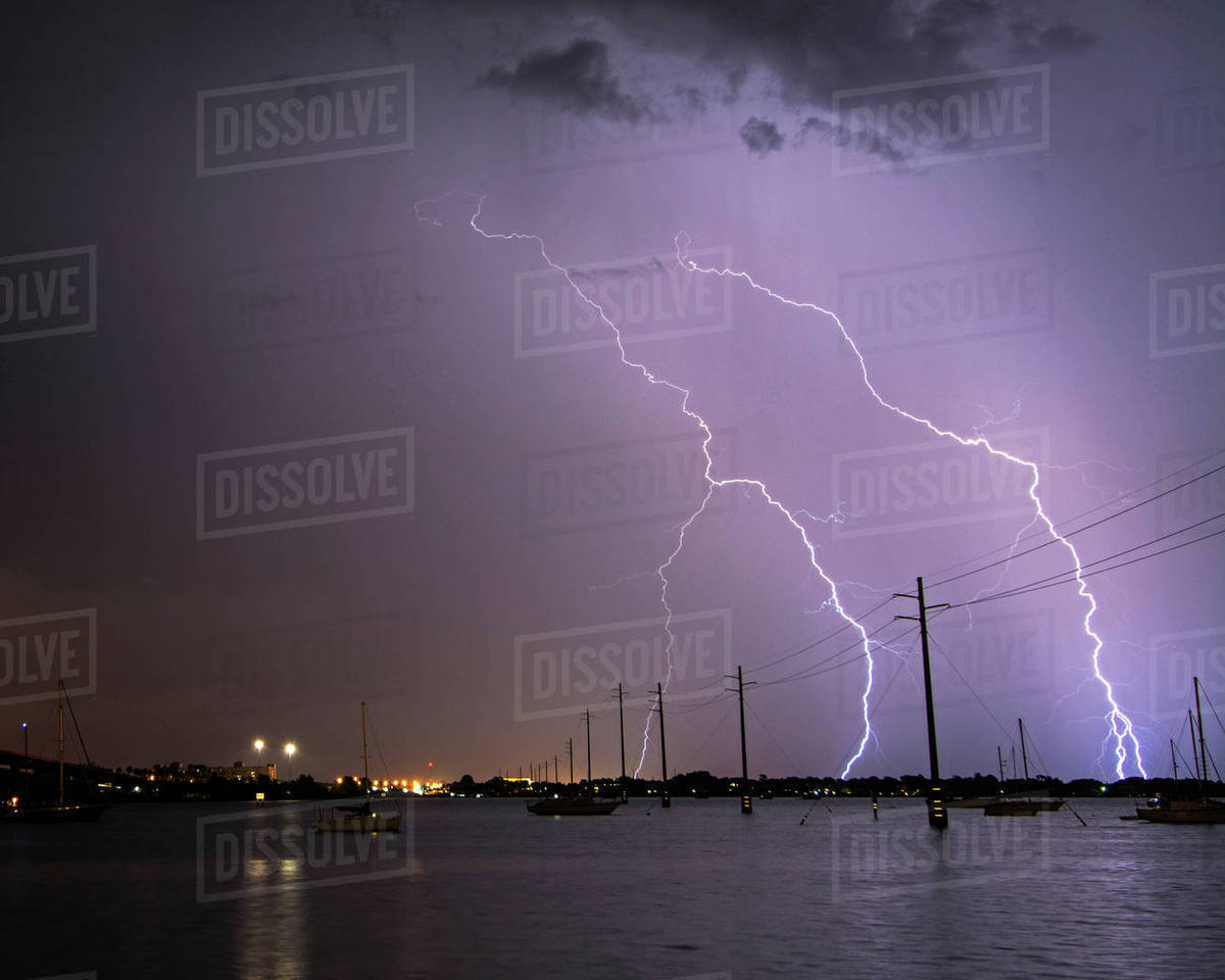 Lightning strikes over boats and power lines at the Indian River Lagoon