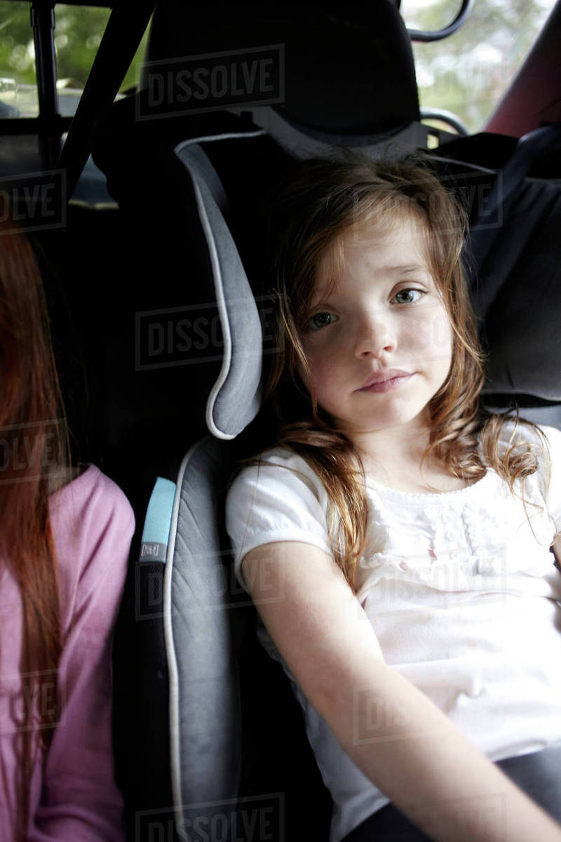 Girl sitting in car seat in backseat Stock Photo Dissolve