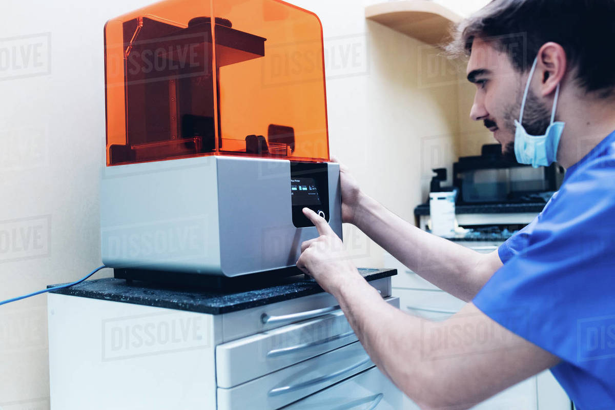 Male dentist using 3D printer Stock Photo Dissolve
