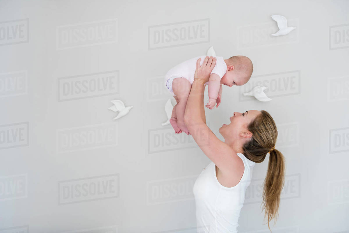 Mother lifting baby up Stock Photo Dissolve