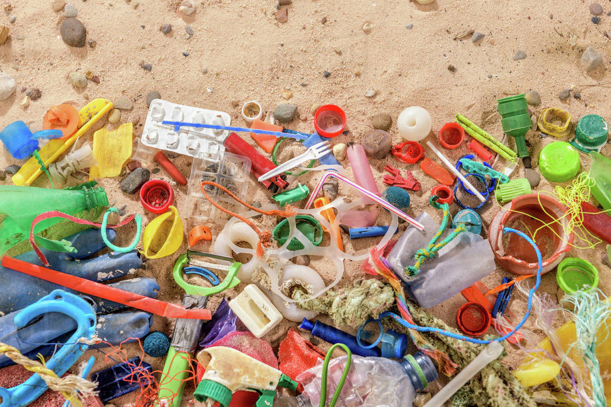 Discarded and polluting plastic garbage on sand collected from beach in