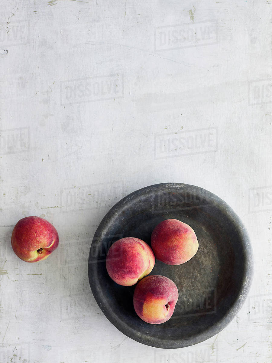 Peaches in bowl Stock Photo Dissolve