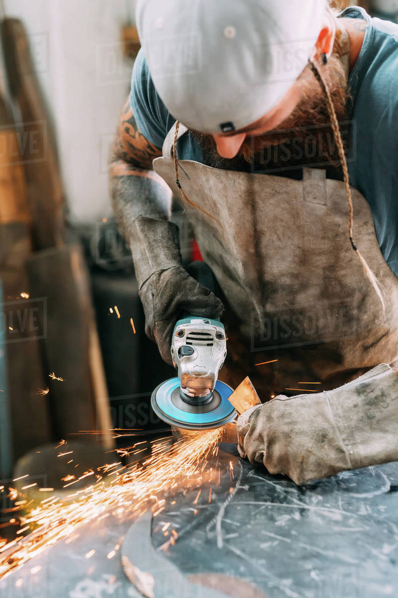 Axe maker using steel grinder in Stock Photo Dissolve