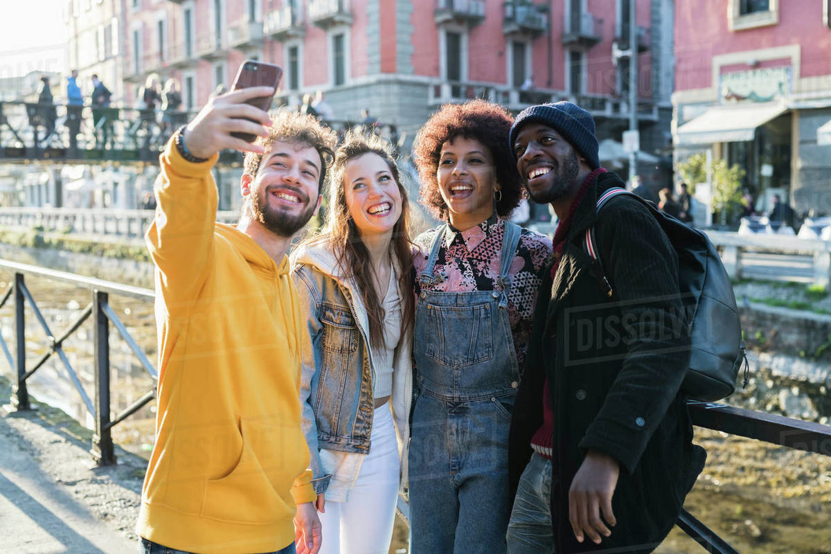 Four female and male young adult friends taking selfie on city canal waterfront Royalty-free stock photo