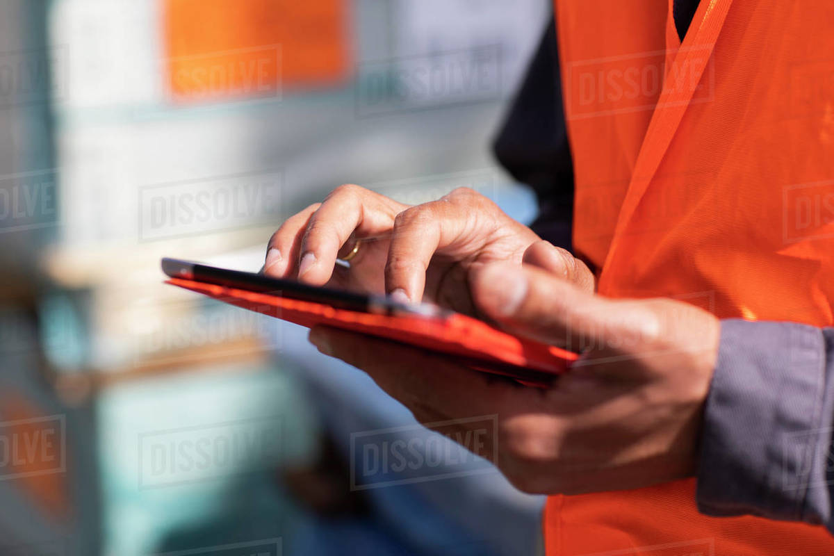 Male engineer on construction site using digital tablet touchscreen, close up of hands Royalty-free stock photo