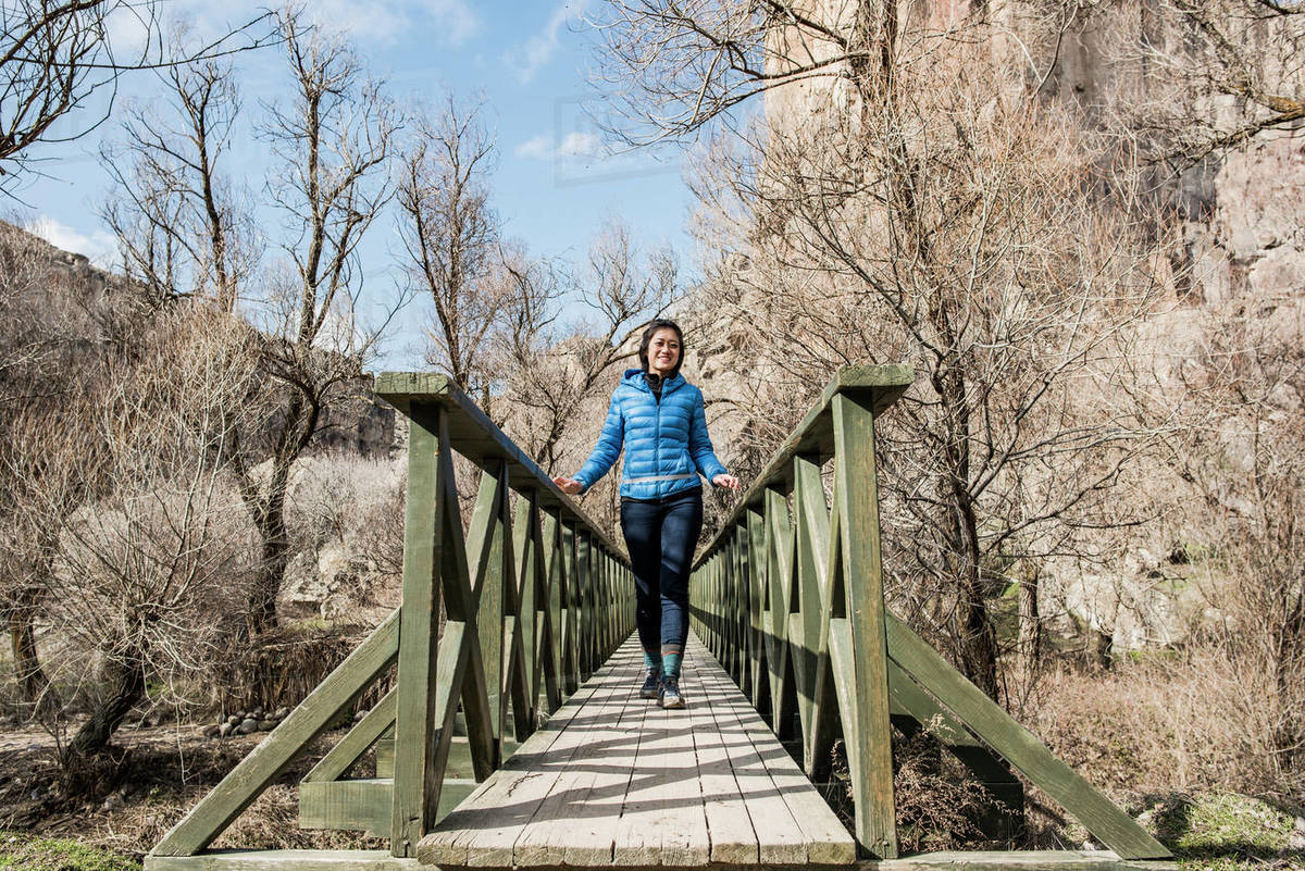 Woman crossing wooden bridge in forest, Göreme, Cappadocia, Nevsehir, Turkey Royalty-free stock photo