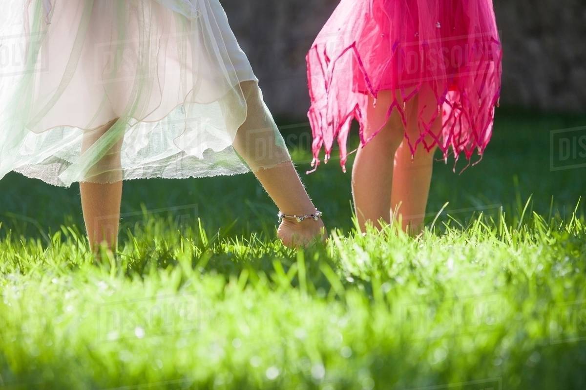 Cropped shot of the legs of two girls in fairy costume in garden Royalty-free stock photo