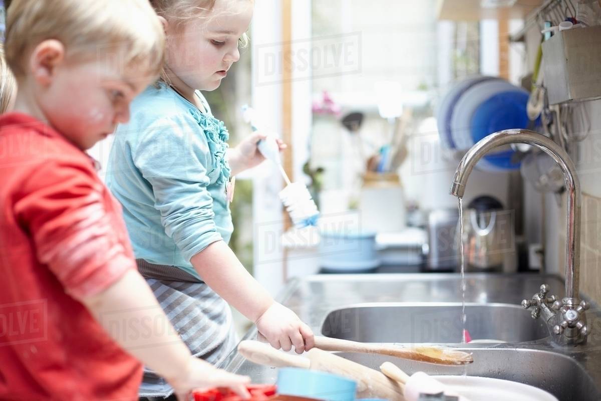 Children washing dishes together Stock Photo Dissolve