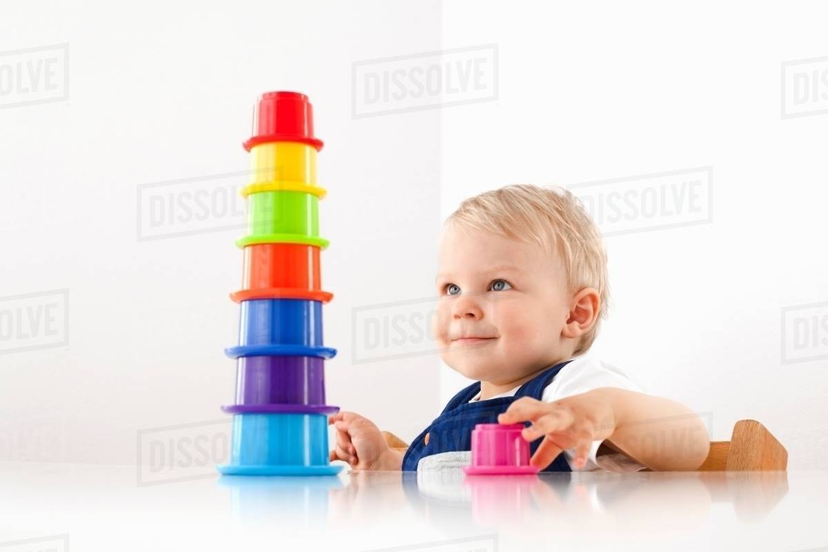 Little boy playing with stacking cups Stock Photo Dissolve
