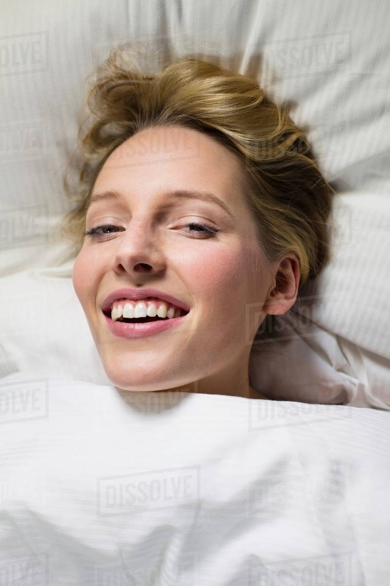Young Woman Under Duvet Head On Pillow Stock Photo Dissolve