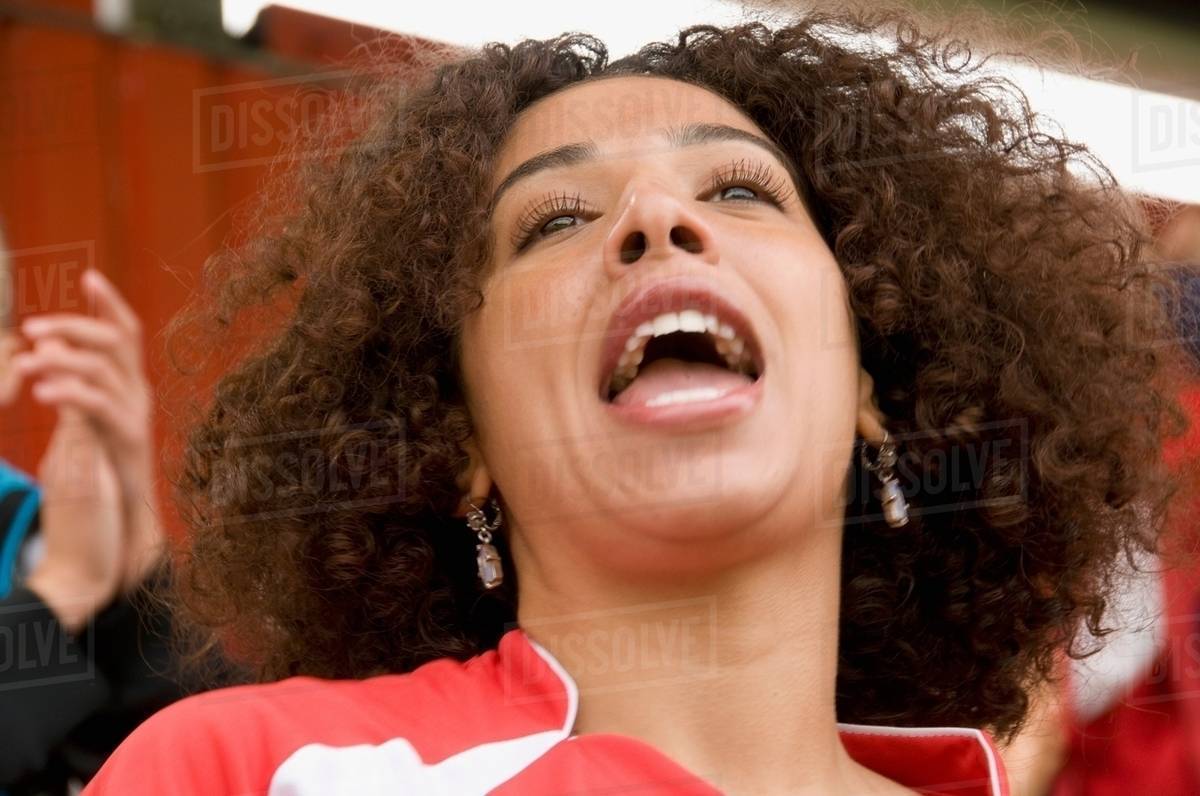 Female fan singing at football match - Stock Photo - Dissolve