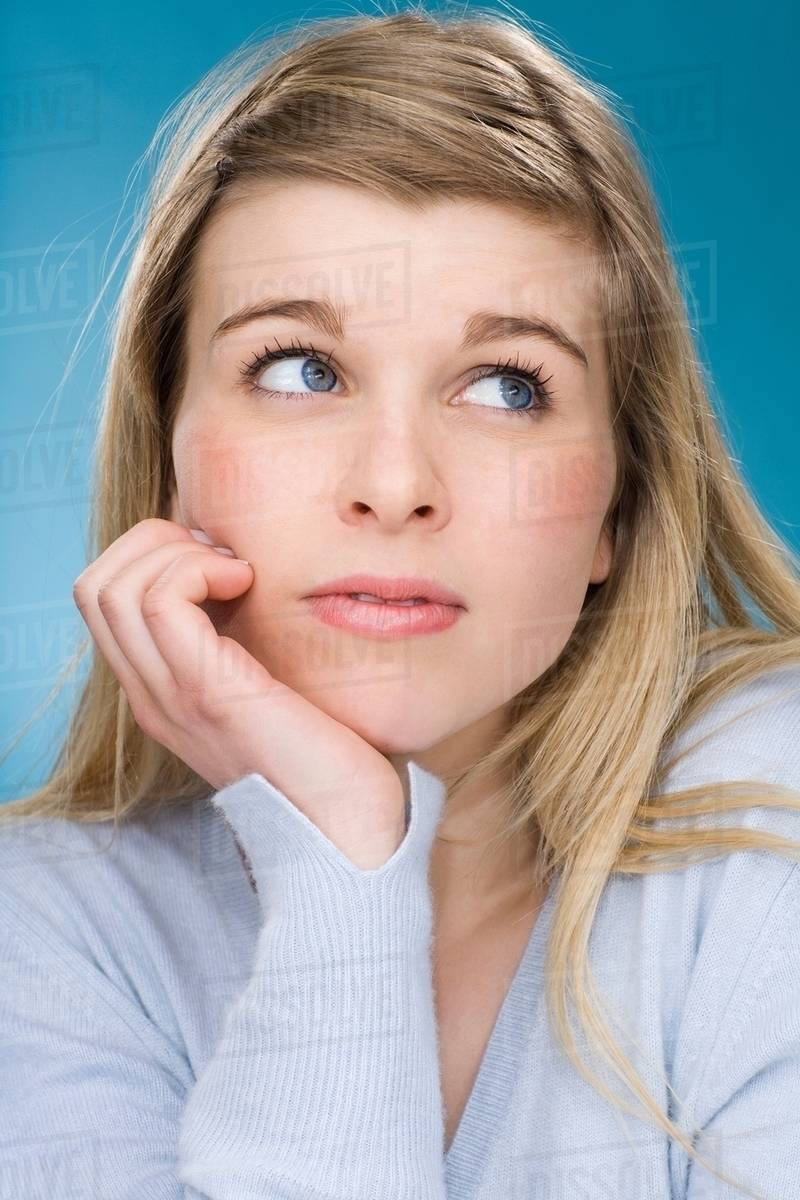 Worried girl resting chin in hand Stock Photo Dissolve