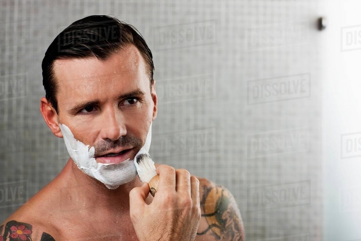 Man lathering shaving cream on face Stock Photo Dissolve