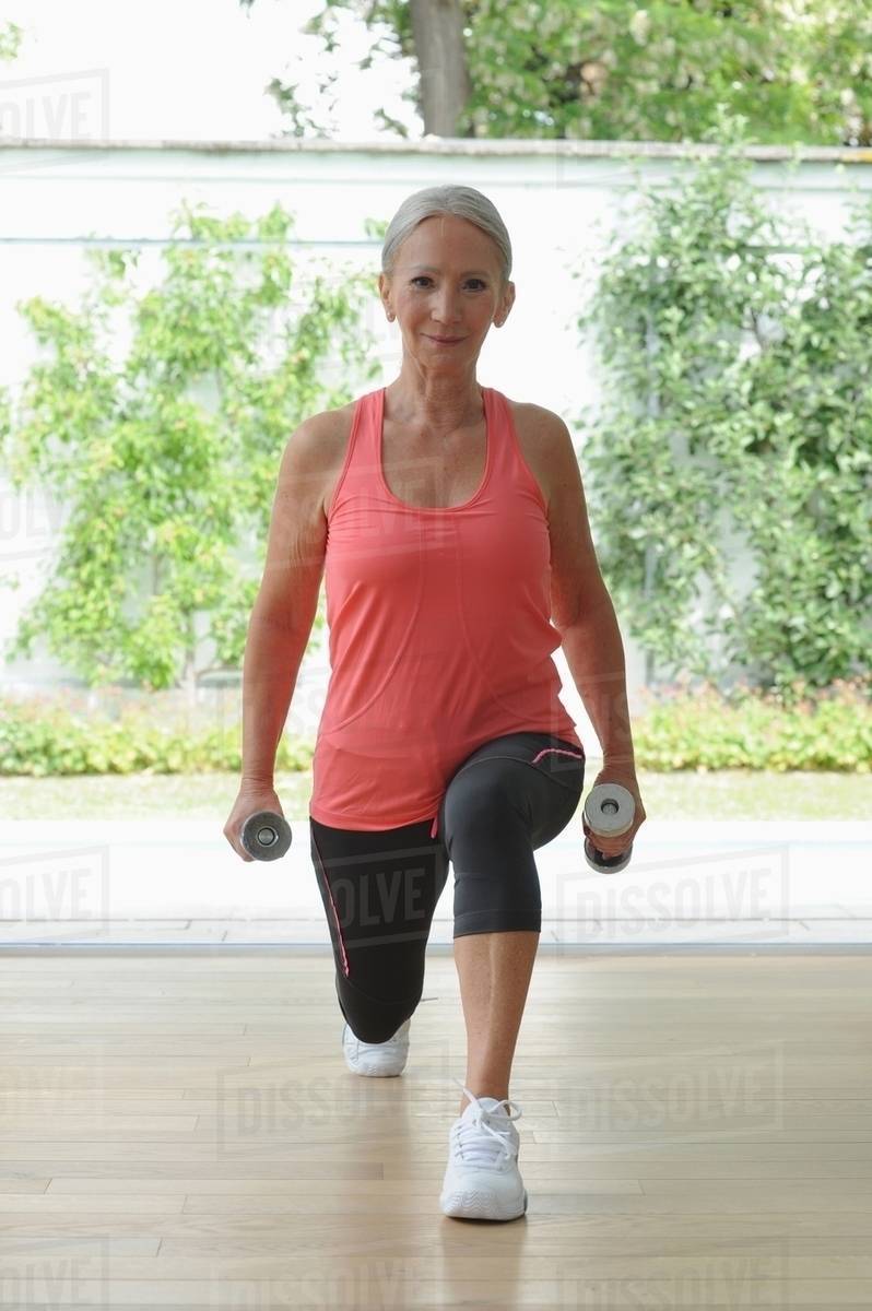 Older woman exercising at home Stock Photo Dissolve